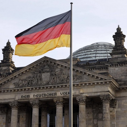 Wehende Deutschlandflagge vor dem Reichstagsgebäude. 