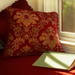 Ein aufgeschlagenes Buch liegt auf einer Fensterbank neben einer Kaffeetasse.