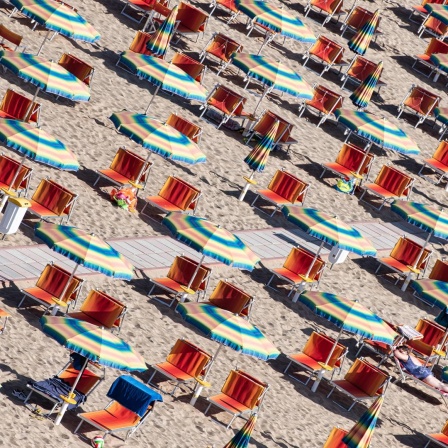 Liegen und Sonnenschirme am Strand der adriatischen Riviera in Italien