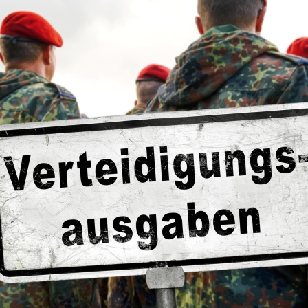 Soldaten stehen vor einem Schild mit der Aufschrift "Verteidigungsausgaben" / FOTOMONTAGE, Symbolbild