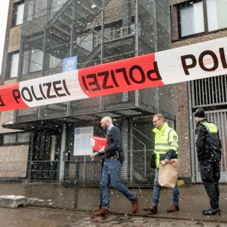 Polizeibeamte stehen vor dem Gebäude der Zeugen Jehovas im Stadtteil Alsterdorf. 