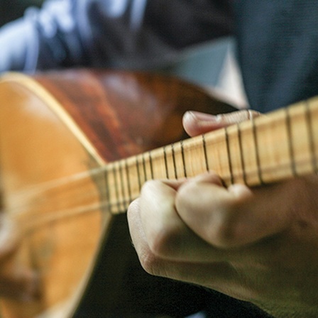 Ein Mann spielt eine Baglama - Saiteninstrument aus der Türkei