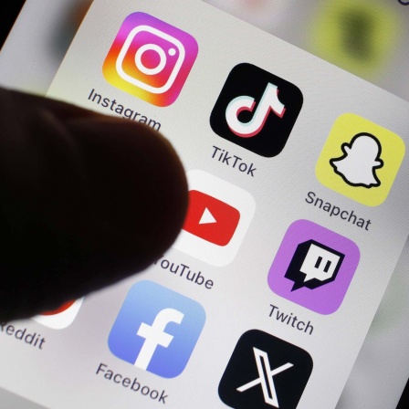 Detailansicht eines Smartphones mit Apps für soziale Medien: Facebook, X, Instagram, Tik Tok, Snapchat, Pinterest und YouTube sind zu sehen.