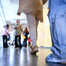 Schüler gehen durch einen Gang zu ihrem Klassenzimmer.