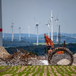 Windpark nördlich von Marsberg, alte Windenergieanlage wird abgerissen. Beton, Stahl und andere Materialien liegen vor einem roten Bagger. Im Hintergrund sind weitere Windräder zu sehen.