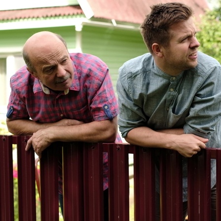 Männer lehnen über dem Gartenzaun