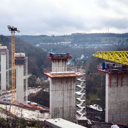 27.11.2024, Nordrhein-Westfalen, Lüdenscheid: Eine Sprecherin der Autobahn GmbH schaut auf die Baustelle der Rahmede-Talbrücke.