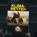 Eine Frau hält ein Plakat in die Höhe auf dem "KLIMA-RETTEN" geschrieben steht