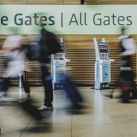 Reisende vor Self-Check-In-Terminals am Flughafen Berlin-Brandenburg