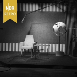 NDR Retro: Ein Studio mit einem Mikrofon über einem Stuhl und Tisch und einer Weltkugel an einer Stange