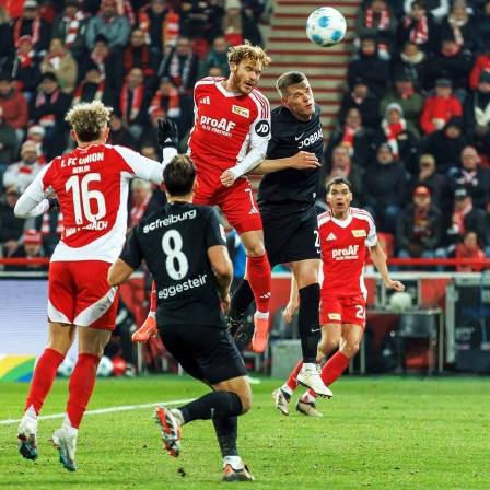 Union Berlins Yorbe Vertessen (Mitte l) geht zum Kopfball gegen Freiburgs Matthias Ginter (Mitte r).