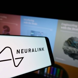 Auf einem Smartphone ist das Symbol und der Name der Firma Neualink zu sehen, im Hintergrund ist eine Intenetseite zum Thema Neurotechnologie zu sehen (Bild: IMAGO / Pond5 Images)