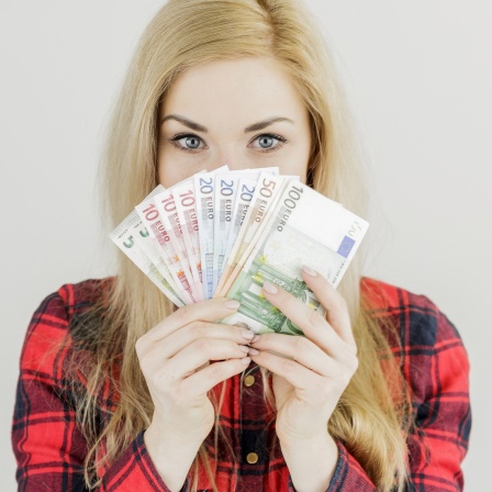 Eine junge Frau hält Geldscheine in der Hand. Symbolbild Grunderbe für alle 18-Jährige.