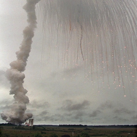 Eine Rauchsäule und verglühende vom Himmel herabregnende Bruchstücke über Französisch Guyana.