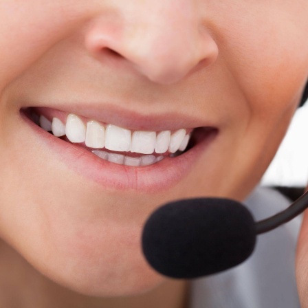 Frau spricht in das Mikrofon eines Headsets