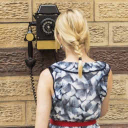 Frau vor einem alten Telefonmodell