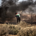Ein Palästinenser schleudert einen Stein über die iraelische Grenze, 25.08.2021.