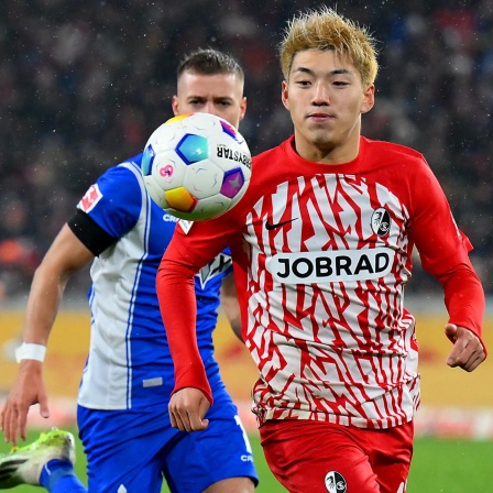 Ritsu Doan (SC Freiburg) wird von Fabian Nürnberger (SV Darmstadt 98) angelaufen