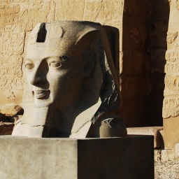 Schon bei ihrer Ankunft in Luxor werden Prof. van Dusen und sein Begleiter vor dem Fluch des Pharao gewarnt. Zu sehen: Eine Pharo-Skulptur vor einer sandfarbenen Wand in Luxor