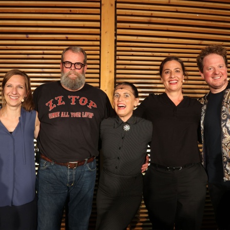 Sarah Hakenberg, Jochen Malmsheimer, Carmela de Feo, Eva Eiselt und Martin Zingsheim stehen lachend vor einer Holzwand