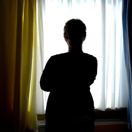 Eine Frau steht in einem Zimmer eines Frauenhauses.