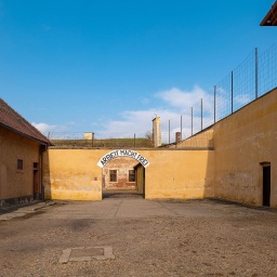 Verwaltungshof im Konzentrationslager Theresienstadt, im Hintergrund das Tor zum Konzentrationslager mit der Aufschrift: Arbeit macht frei
