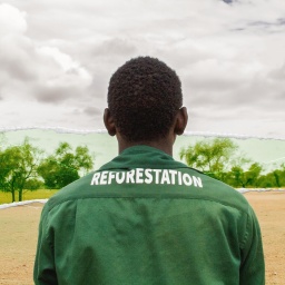 Ein Mitarbeiter der "Großen Grünen Mauer" mit einem Overall, auf dem das Wort "Reforestation" zu lesen ist