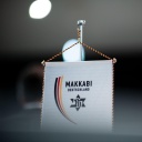 Ein Wimpel mit dem Logo der Makkabi-Bewegung steht auf einem Tisch.
