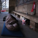 Eine obdachlose Person liegt in einem Schlafsack in Düsseldorf im Freien