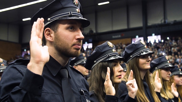 Zeynep Yalcin und Gabriel Ben legen gemeinsam mit 1.136 anderen Polizeianwärtern den Diensteid ab. In einem dreijährigen Studium werden sie an der Polizeiakademie in Oldenburg zu Polizeikommissar*innen ausgebildet.