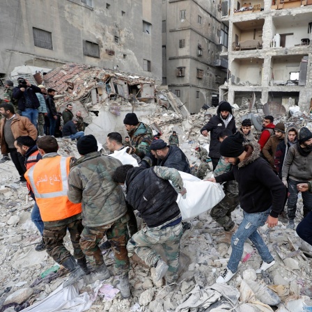 Rettungsteams tragen ein Opfers des Erdbebens aus einem zerstörten Gebäude