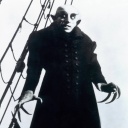 Der Stummfilm-Vampir Nosferatu steht auf einem Schiff und sieht gruselig aus.