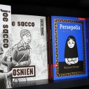 Auf einem Regal stehen zwei Bände von Joe Sacco und der Comic "Persepolis" von Marjane Satrapi aus dem Verlag Edition Moderne. 