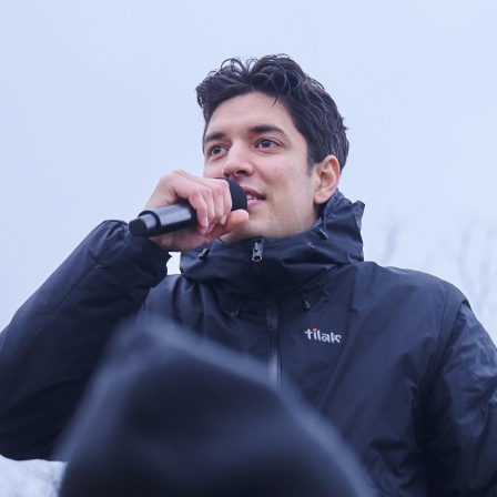 Apsilon, Influencer und Sänger singt während einer Demonstration gegen rechts auf einer Bühne. 
