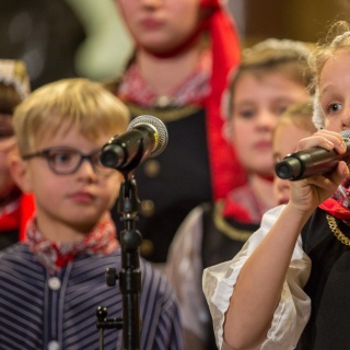 Ein Mädchen in traditioneller Tracht singt für die Lütt Finkwarder Speeldeel beim Weihnachtshafenkonzert im Hamburger Michel.