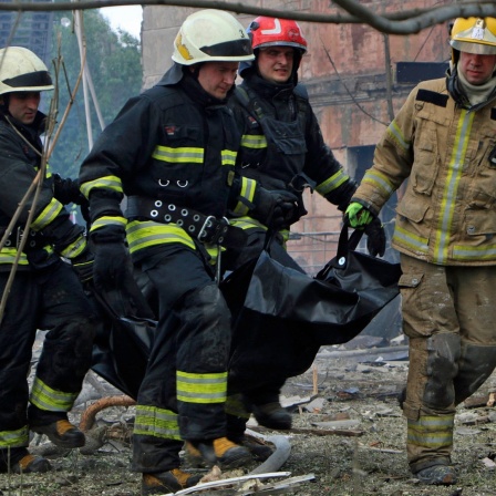 Auf diesem vom Staatlichen Katastrophenschutz der Ukraine zur Verfügung gestellten Foto tragen Feuerwehrleute eine Leiche nach einem, nach ukrainischen Angaben, russischen Luftangriff.