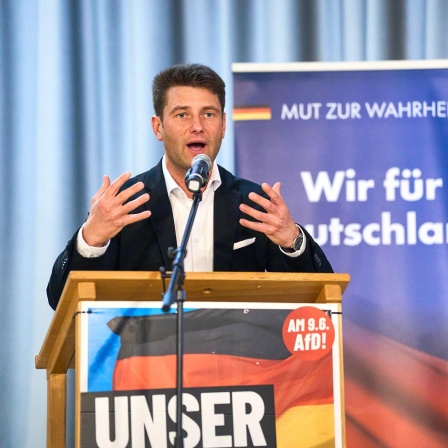 Der Politiker René Aust auf einer Bühne.