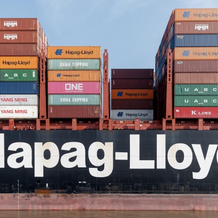 Der Schriftzug "Hapag-Lloyd" steht an der Bordwand eines Containerschiffs der gleichnamigen Reederei.