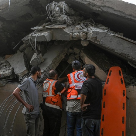 Hilfskräfte suchen nach Verletzten in einem zerstörten Gebäude in Khan Yunis in Gaza.