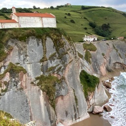 eine Steilküste in BAskenland, auf dem hohen Felsen ist ein Haus gebaut