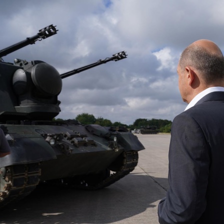 Bundeskanzler Olaf Scholz (SPD) besucht das Ausbildungsprogramm für ukrainische Soldaten an dem Flugabwehrkanonenpanzer Gepard und steht vor einem Gepard Panzer