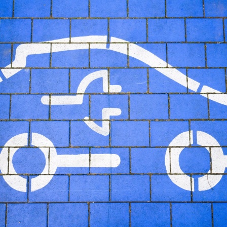Ein blaues Symbol mit einer Steckdose für ein Auto steht für Batterietechnik im Automobilbereich