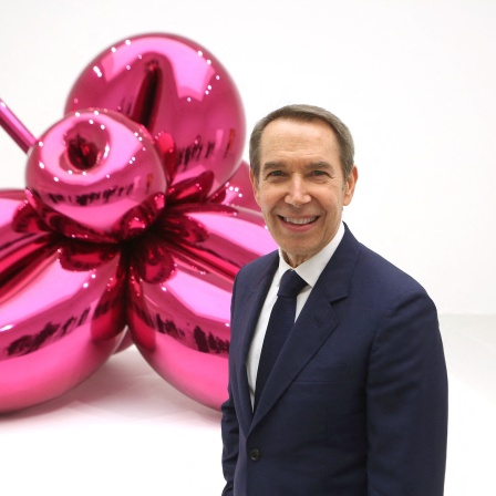 Der Künstler Jeff Koons steht vor einer seiner Skulpturen