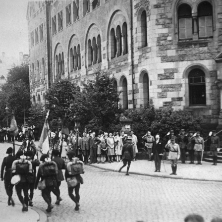 Die letzten Truppen der Allierten ziehen aus Trier aus. Im Vordergrund grüßend General Dupois, 27. Juni 1930