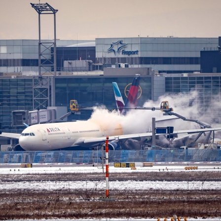 Winter am Flughafen Frankfurt Ein Flieger wird am Terminal enteist.