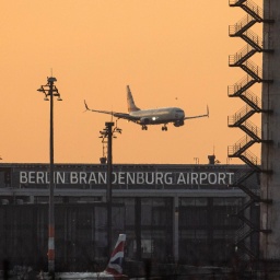 Ein Flugzeug landet zum Sonnenaufgang am Flughafen Berlin Brandenburg (BER).