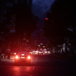 Auto fährt über dunkle Straße bei Stromausfall in der Stadt