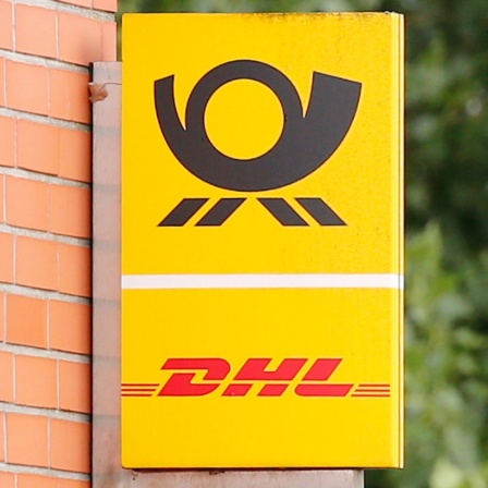 Das Logo der Deutsche Post DHL Group an einer Häuserwand