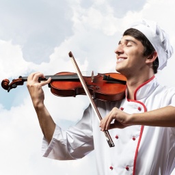 Ein Koch in Berufsbegleitung spielt auf einer Geige.