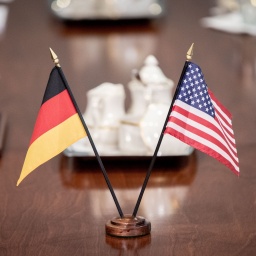 Die Flaggen von Deutschland und der USA stehen auf einem Holztisch. Wie kann die deutsche Politik die Zusammenarbeit zwischen Deutschland und den USA weiterführen, ohne dabei Präsident Trump zu brüskieren? Es herrscht viel Ratlosigkeit.